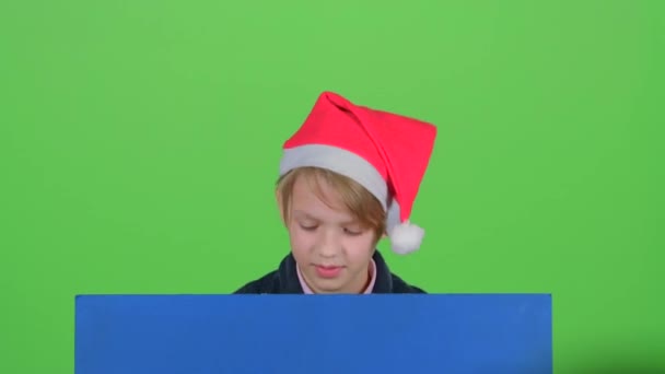 Adolescente en el sombrero aparece de un tablero en una pantalla verde — Vídeos de Stock