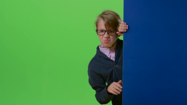 Руки хлопчика беруть на дошку, а потім дитина демонструє нелюбов, а потім як на зеленому екрані — стокове відео