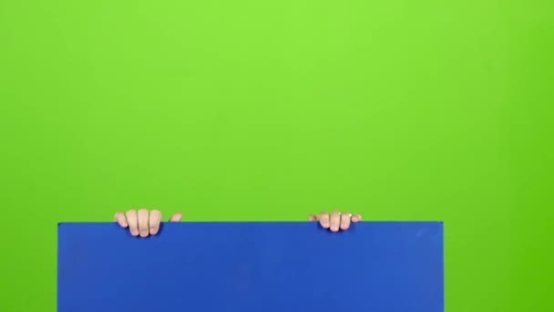 Tonåring i cap dyker upp bakom styrelsen på en grön skärm. Slow motion — Stockvideo