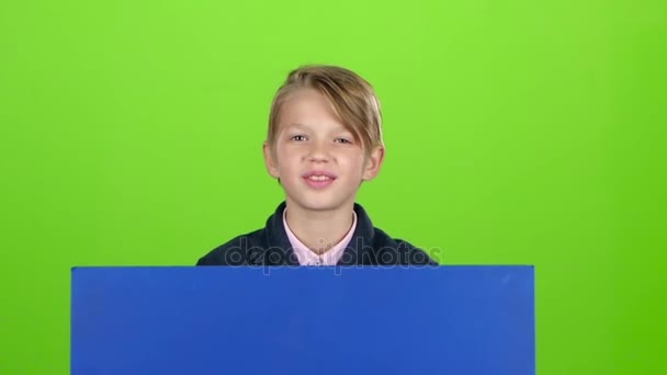 Niño asomándose por detrás de las olas del cartel azul una mano delante de la pantalla verde. Movimiento lento — Vídeos de Stock