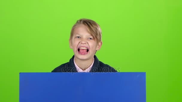Barn pojken dök upp bakom en blå affisch flinar kurvor av ansikten och dolda igen. Grön skärm. Slow motion — Stockvideo