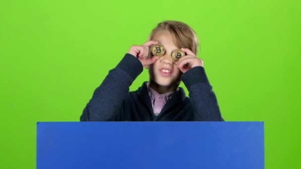 Adolescente emerge de trás do tabuleiro com dois chips e mostra a língua em uma tela verde. Movimento lento — Vídeo de Stock