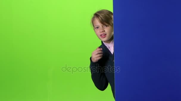 ティーンエイ ジャー peeks 後ろからと緑色の画面上の顔のカーブに乗る。スローモーション — ストック動画