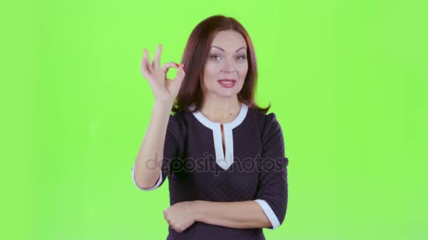 Woman flirts and winks with the men and shows ok. Green screen — Stock Video