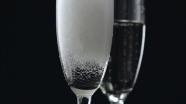 Şampanya şişesinden siyah arka plan üzerine iki gözlük içine dökme. Yakın çekim