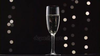 Soğutulmuş bardak şampanya. Bokeh arka plan siyah yanıp sönen