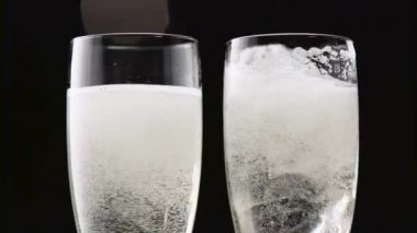 İki alt buzlu şampanya flüt. Bokeh arka plan siyah yanıp sönüyor. Yakın çekim