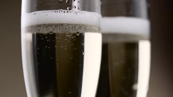 Lleno de dos copas de champagne silbido y espuma de burbujas blancas. De cerca. — Vídeo de stock