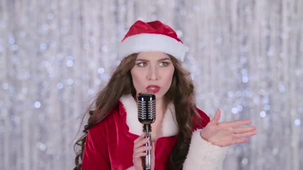 Santa nő énekel egy retro mikrofon. Bokeh háttér. Közelről — Stock videók