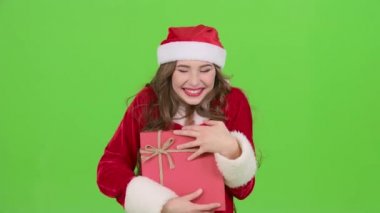 Kız kar kızlık kostümlü bir hediye tutar. Yeşil ekran. Yakın çekim
