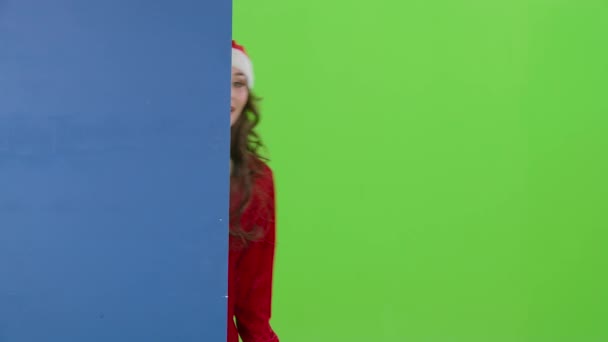 Santa nő néz ki a kék tábla és mutat egy remek-megjelöl. Zöld képernyő — Stock videók