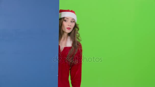 Santas assistant regarde hors du tableau bleu et montre un pouce vers le bas. Écran vert — Video