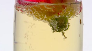 Rosebud bir bardak şampanya ile doldurur. Beyaz arka plan. Yakın çekim