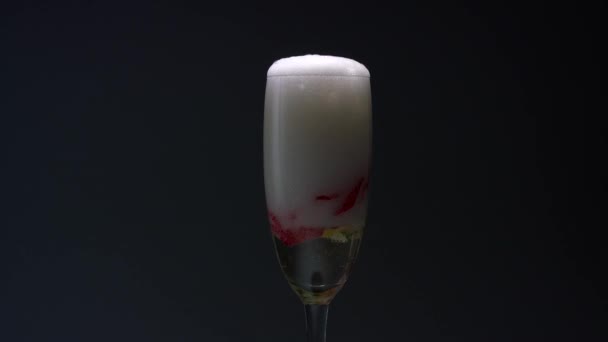 Bocciolo di rosa nella parte inferiore del bicchiere, il cameriere versa champagne in esso. Fondo nero — Video Stock