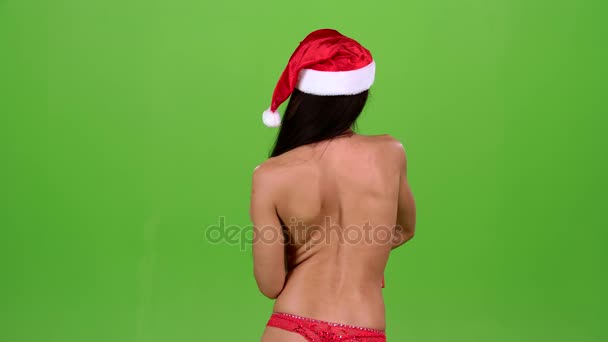 Девушка в рождественской шляпе поворачивается с подарком в руках. Зеленый экран. Медленное движение — стоковое видео