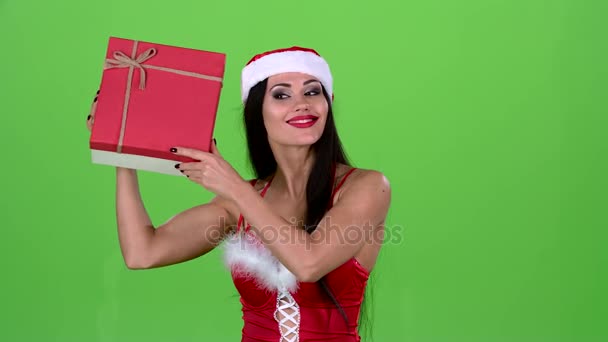 Девушка в новогоднем костюме держит в руке подарок. Зеленый экран. Медленное движение — стоковое видео