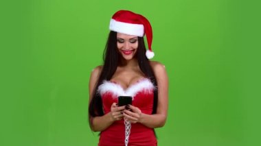Santa kadın bir telefon elinde tutan ve fotoğraf, Göz kırpmalar başparmak. Yeşil ekran