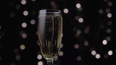 İçinde dönen bir şampanya kabarcıklar. Bokeh arka plan