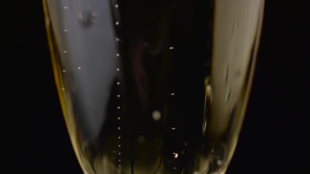 Le bollicine di una bevanda frizzante salgono sul bicchiere. Fondo nero. Da vicino. — Video Stock