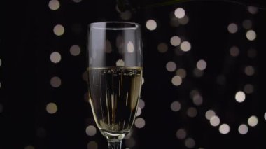 Şampanya cam içine dökülür. Bokeh arka plan