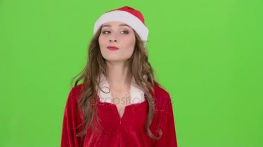 Kar Maiden Kırmızı elbiseli kız winks ve onun parmağını ok gösterir. Yeşil ekran. Yakın çekim. Ağır çekim