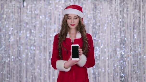 Santa femme tient le téléphone dans ses mains et regarde au loin. Fond Bokeh. Mouvement lent — Video