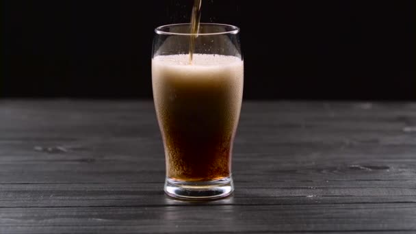 Cola se vierte en vidrio sobre fondo negro — Vídeo de stock