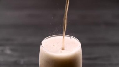 Cam ile buz küpleri ve o içine dökülen kola kenar üzerinde köpük akan taşıyor. Yakın çekim