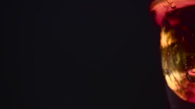 Soğutulmuş gazlı cola bardak siyah bir arka plan üzerinde görüntülenir. Yakın çekim