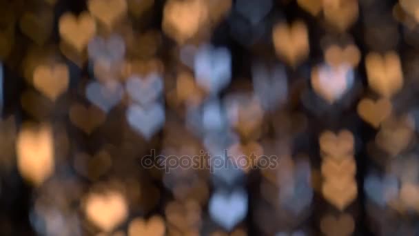 Brillantes luces parpadeantes en forma de corazón contra. Fondo de Bokeh — Vídeo de stock