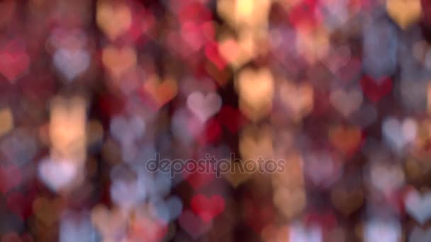 Hermoso bokeh glamour en tonos de rojo, amarillo y azul en forma de corazón — Vídeos de Stock