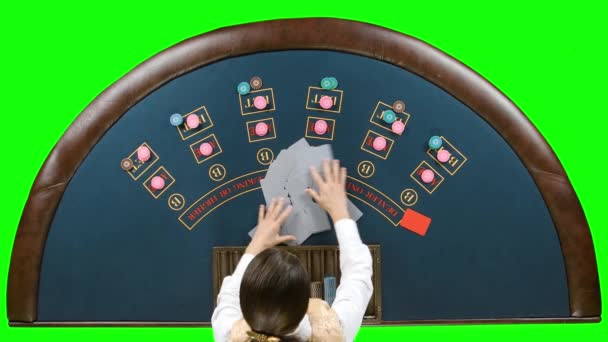 Spacciatore che gestisce carte da gioco a un tavolo da poker. Schermo verde — Video Stock