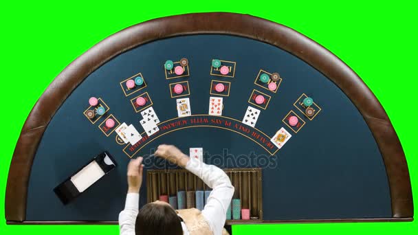 Дилер за покерным столом кладет фишки под игру в покер. Зеленый экран. Вид сверху — стоковое видео