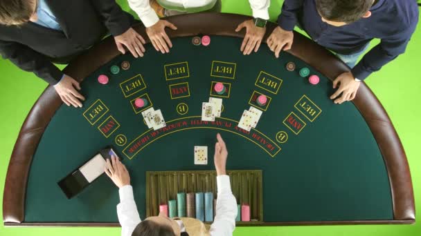 Erkekler, masada poker oynamaya satıcı kartları ve fişleri fırsatlar. Yeşil ekran. Üstten Görünüm — Stok video