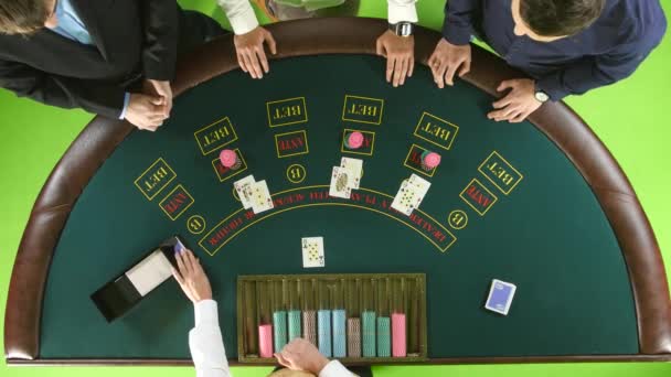 Les joueurs jouent au poker au casino à la table verte. Écran vert. Vue du dessus — Video