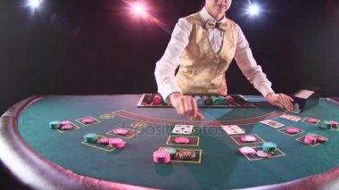 Casino satıcı kadın poker oyun kartları dağıtır. Siyah arka plan. Ağır çekim