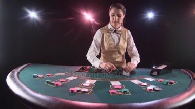 Casino satıcı iskambil poker masasında işleme. Siyah arka plan. Ağır çekim