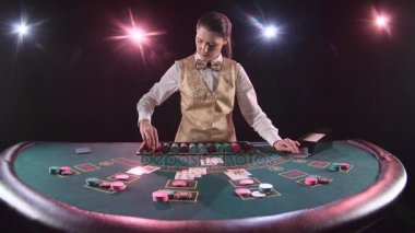 Casino satıcı bir ayakkabı kartları bırakır fiş bir poker masasında ortaya çıkarır. Siyah arka plan. Ağır çekim