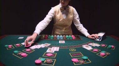 Poker satıcı tablo güvertede dışarı fanning iskambil karıştırma. Siyah arka plan. Ağır çekim