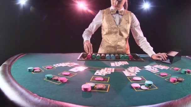 Casino distribuidor mujer toma las cartas del titular de la tarjeta para el juego en el póquer. Fondo negro. Movimiento lento — Vídeo de stock