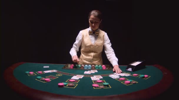 Autopsie des trois cartes sur le flop, jeu de poker sur la table verte. Fond noir. Mouvement lent — Video