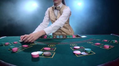 Kumarhane krupiye kız poker kartları ve performans gösteren hüner ile kartları karıştırır. Duman. Ağır çekim