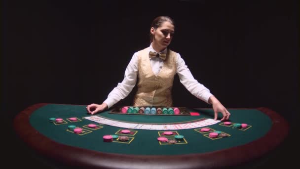 Il croupier professionista del casinò mescola le carte da poker ed esegue trick con le carte. Fondo nero. Rallentatore — Video Stock