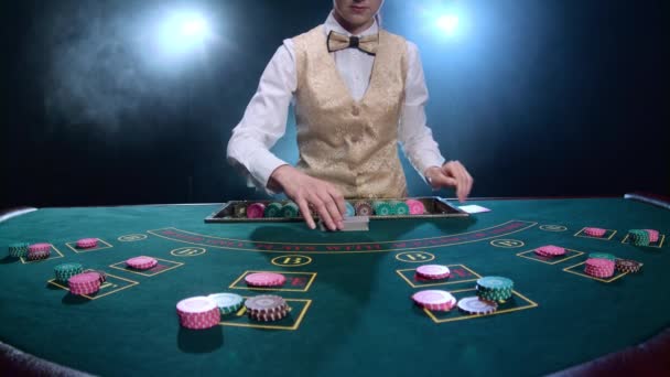 Dealer behandeling speelkaarten aan een pokertafel. Rook. Slow motion — Stockvideo