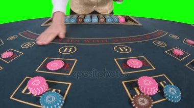 Profesyonel iskambil üç kart koymak bir poker masasında işleme krupiye önünde flop vardır. Yeşil ekran. Ağır çekim. Yakın çekim