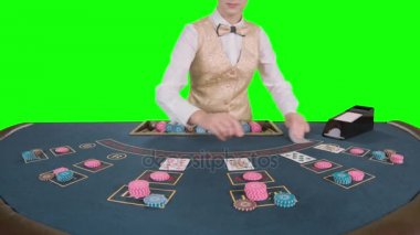 Kumarhane krupiye kadın oyun poker için kart sahibinden kartları alır. Yeşil ekran. Ağır çekim