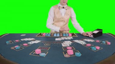 Kumarhane krupiye kız Barbut masada ayakta kartları oyun poker için kart sahibinden alır. Yeşil ekran. Ağır çekim