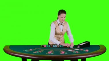 Kumarhane krupiye ayakta beyaz bir gömlek yarım daire biçimli tabloda arkasında kartları oyun poker için kart sahibinden alır. Yeşil ekran. Ağır çekim
