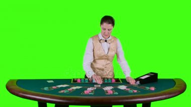 Tablo poker üç kartları flop için kumarhane krupiye ayakta beyaz bir gömlek yarım daire biçimli masanın arkasında dağıtır. Yeşil ekran. Ağır çekim