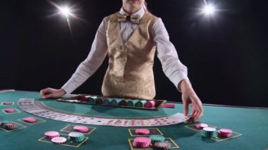 Kumarhane krupiye kadın poker kartları ve performans gösteren hüner ile kartları karıştırır. Siyah arka plan. Parlak ışık. Ağır çekim